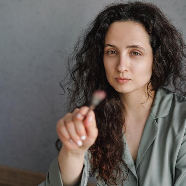 Serene woman meditating in a beautiful, light-filled yoga studio.